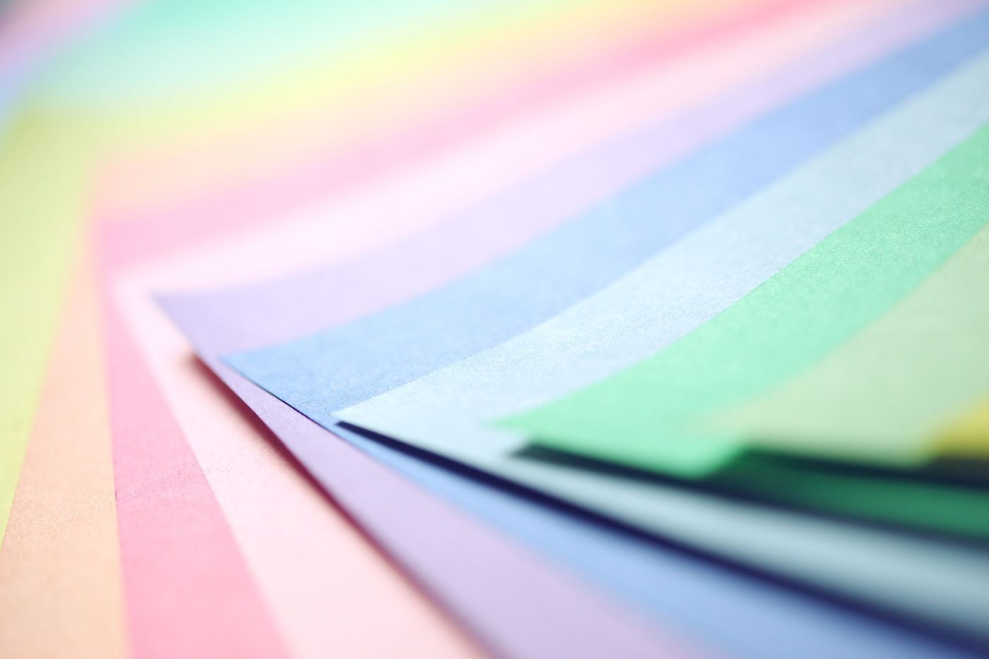 Sheets of pastel-coloured paper layered on top of each other