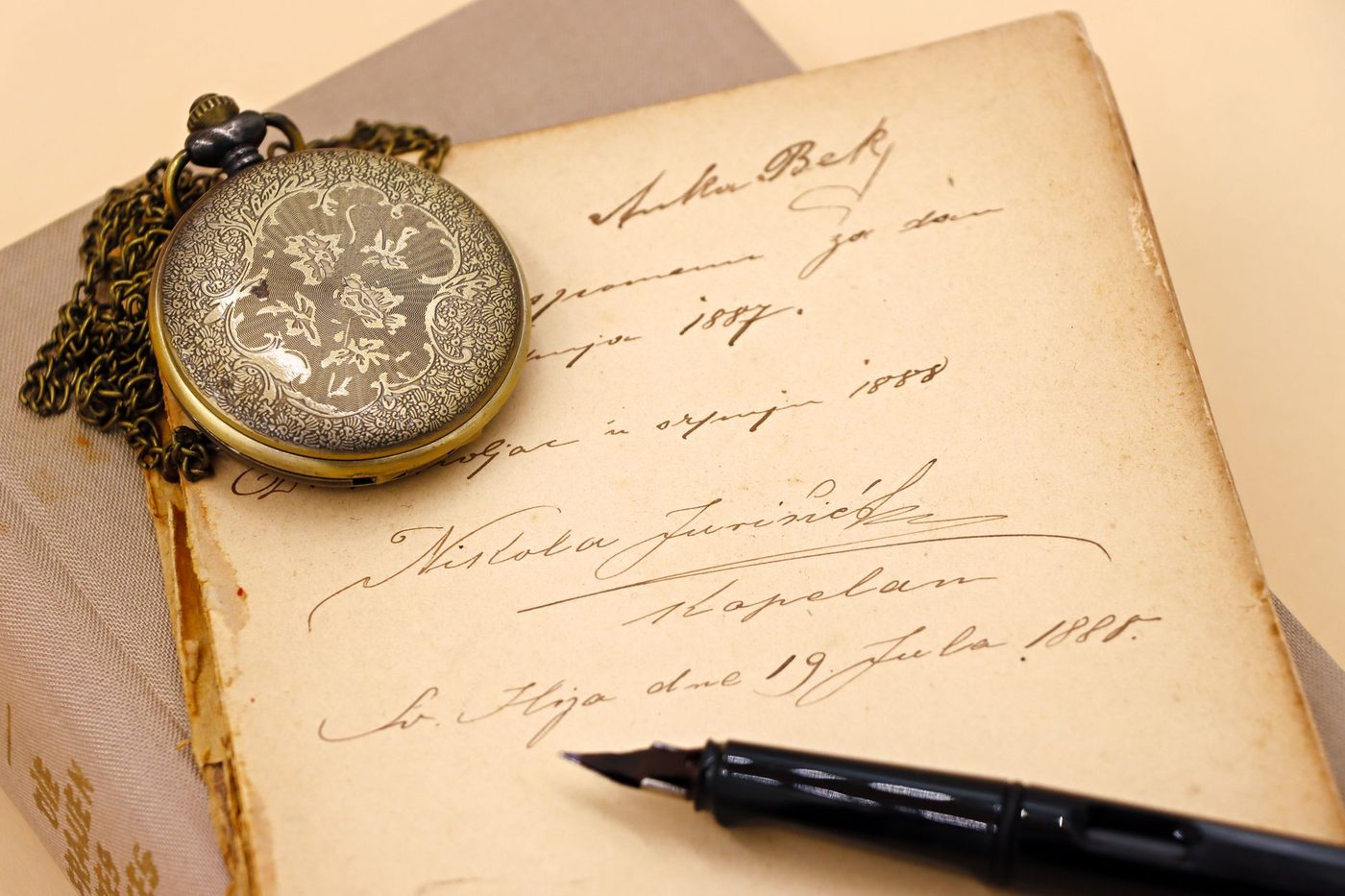 Old handwritten diary with a pocket watch and a fountain pen